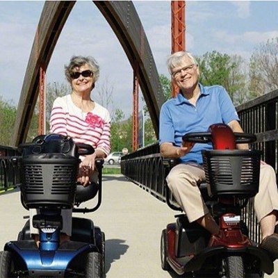 Shop Now or Buy now buttons.
Couple both riding mobility scooters on a bridge.